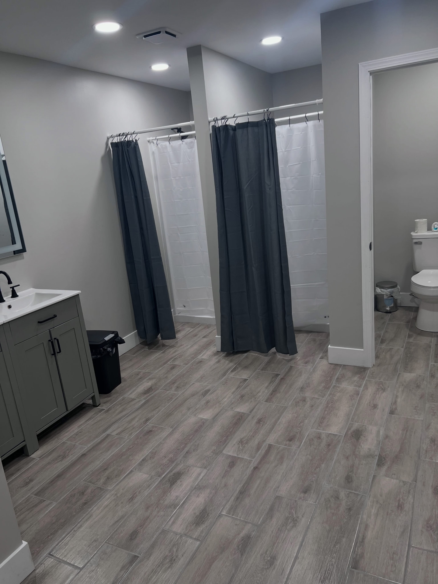 Clean locker room with private showers, vanity and restroom