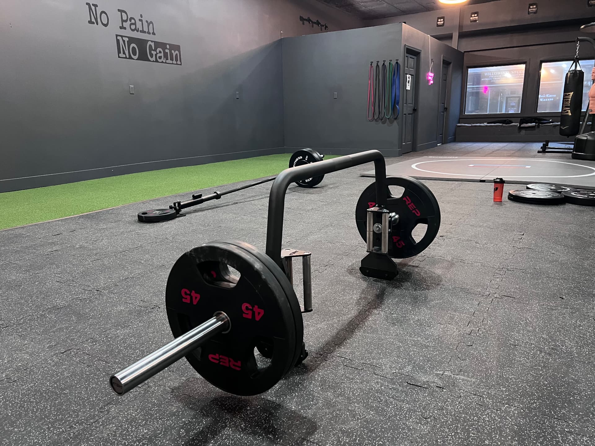 Loaded trap bar with REP plates on the training floor
