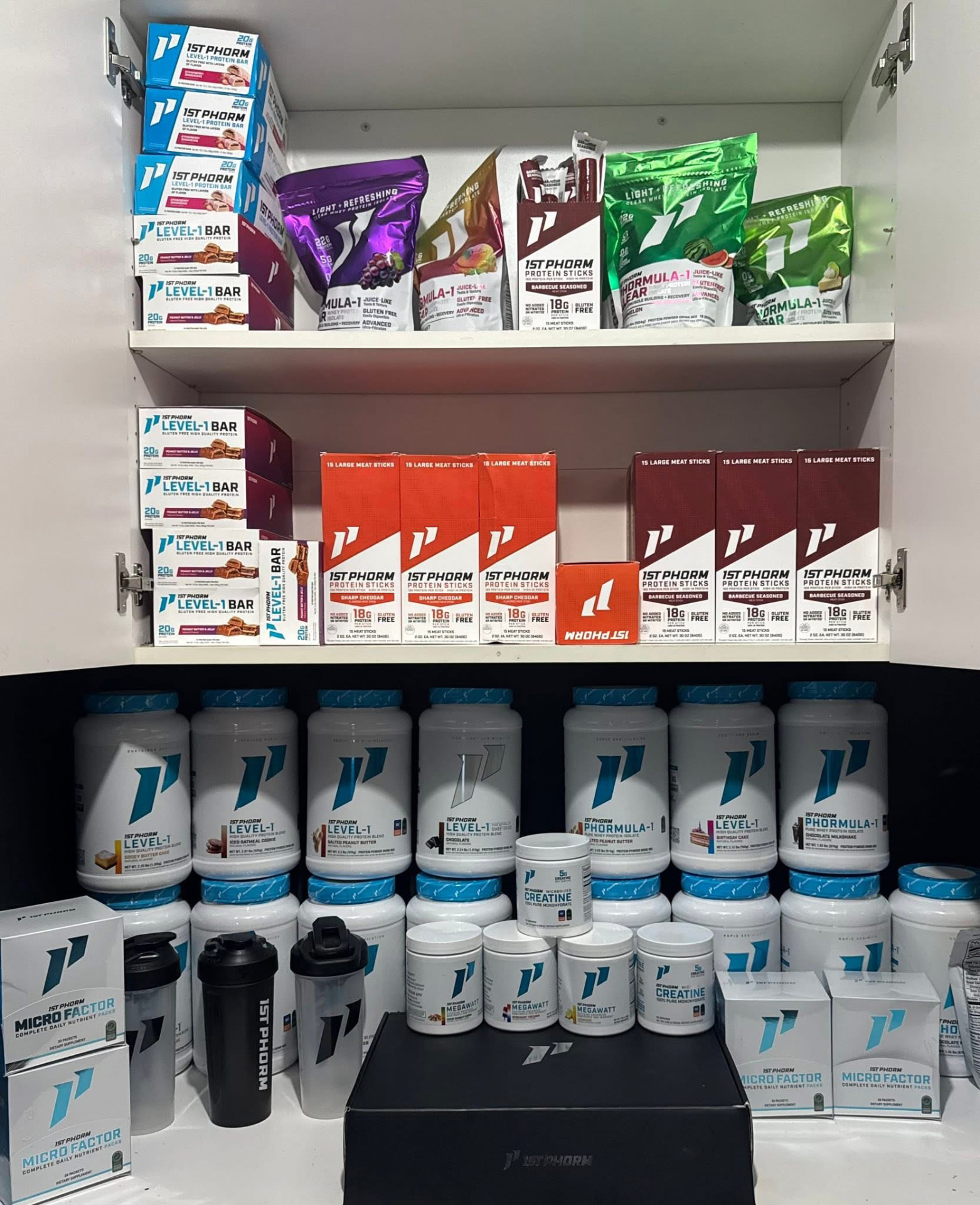 Supplement shelf stocked with 1st Phorm protein powders, bars and protein sticks