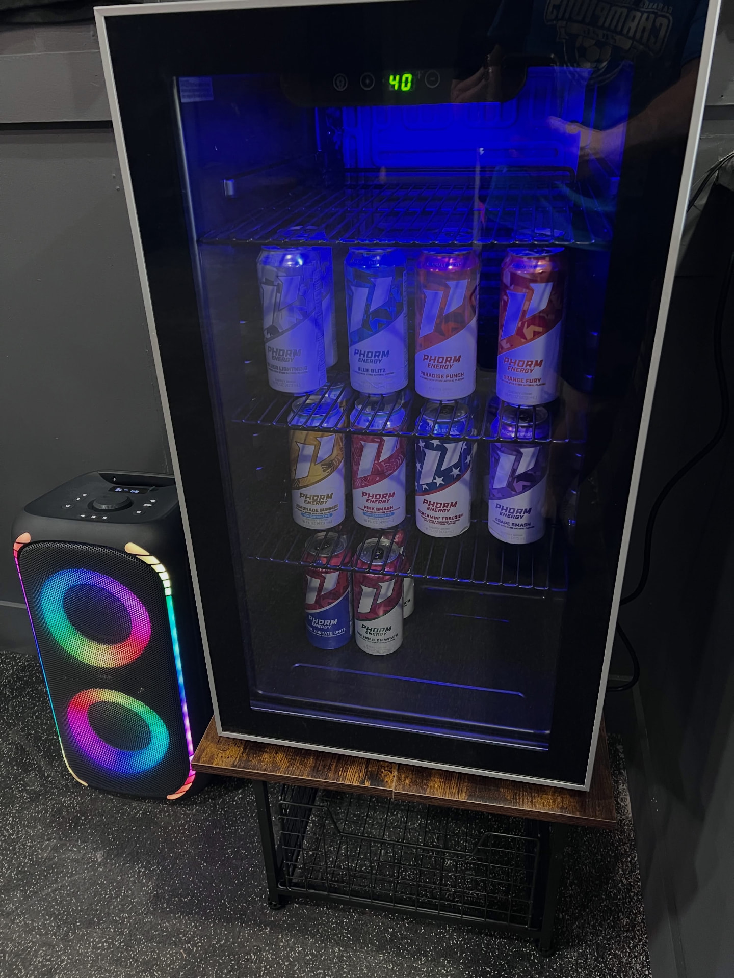 Cooler stocked with cold Phorm Energy drinks next to a speaker